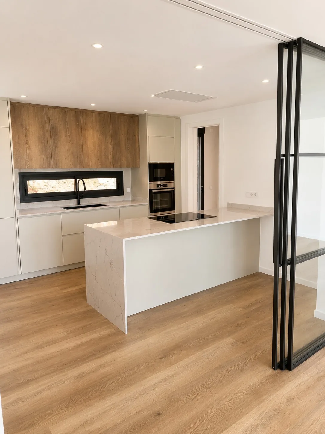 Cocina con isla de mármol, muebles de roble y vidriera negra